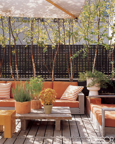 An orange couch on a wooden terrace.