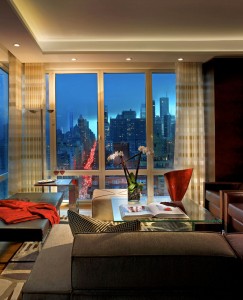 A living room with a floor to ceiling window showcasing a city view.