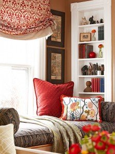 A window seat in a living room with mixing patterns.