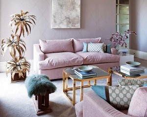 A living room with a pink couch and pastel accents.