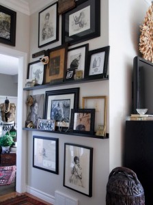 A living room with lots of framed pictures on the walls.