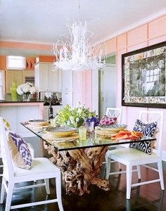A pastel-themed dining room with pink walls and white chairs.