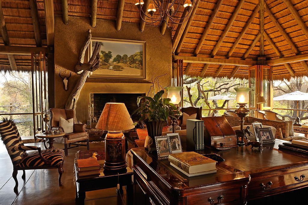 A living room with a safari-inspired fireplace and a desk.