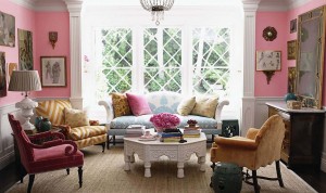 A living room with eclectic pink walls and furniture.