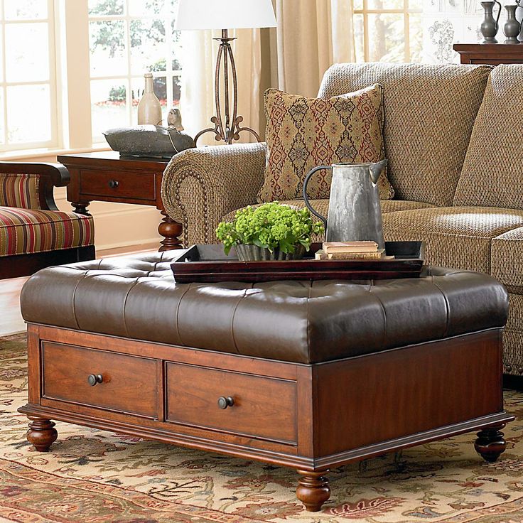 A brown leather ottoman in a living room.