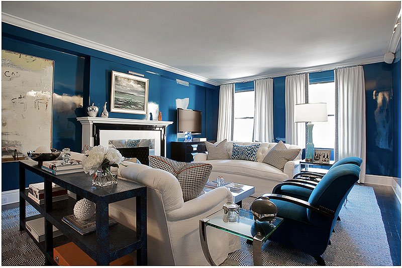A living room decorated with blue walls and white furniture.