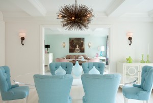 A dining room with pastel blue chairs and a chandelier.