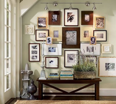 A hallway with many framed pictures on the walls and a bench.