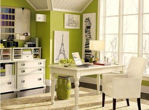 A cozy home office with a green accent wall.