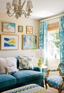 A living room with mixing patterns on a blue couch and blue curtains.
