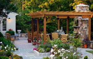 An outdoor living space with a stone patio and a wooden pergola.