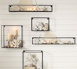 A wall of shelves showcasing candles and seashells.