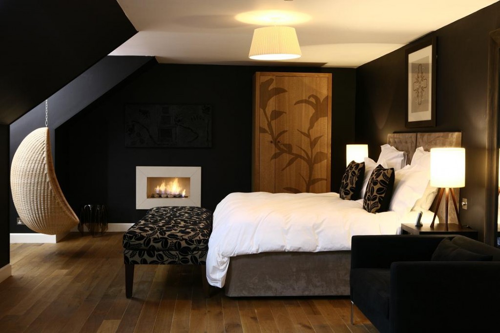 A bedroom showcasing black walls and a fireplace, perfect for decorating with black.