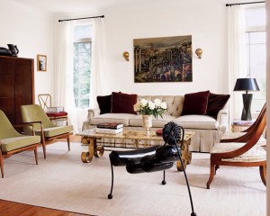 A living room with white furniture and an eclectic large painting.