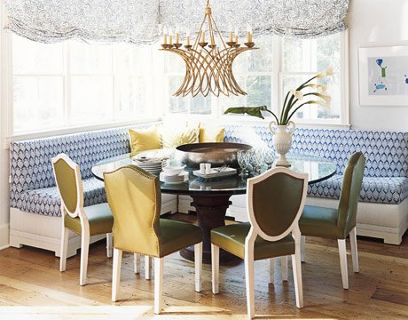 A dining room with banquette seating and a chandelier.