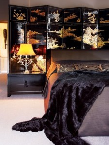 A black, gold bedroom with folding screens.