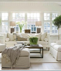 A living room decorated predominantly in white, featuring an abundance of white furniture.