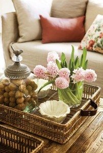 A wicker tray with flowers and nuts.