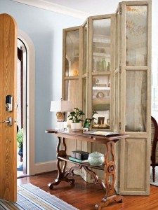 An entryway with a wooden table, chairs, and folding screens.
