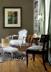 A living room with animal print rug and chairs.