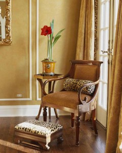 A living room with an animal print chair and ottoman.