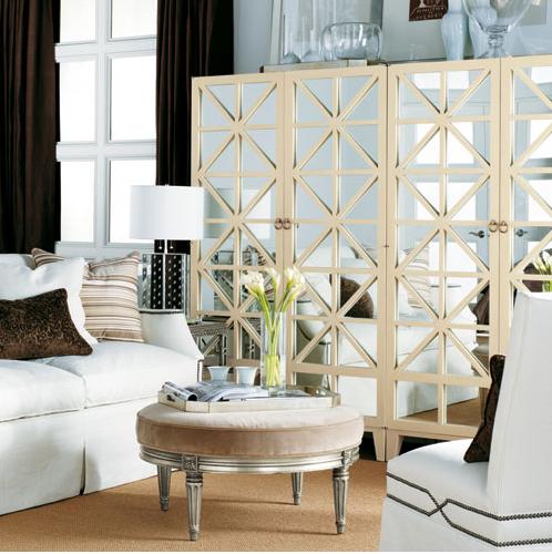 A living room with white furniture, mirrors, and folding screens.