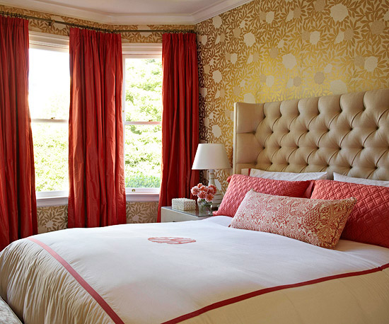 An upholstered bed with a red and white comforter.