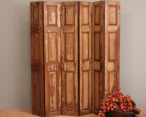 A wooden folding room divider with a flower in the middle.