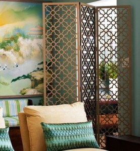 A living room with a painting and folding screens on the wall.