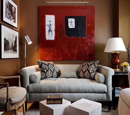 A small living room with a red painting on the wall.