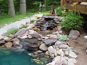A backyard water feature with rocks and a waterfall.
