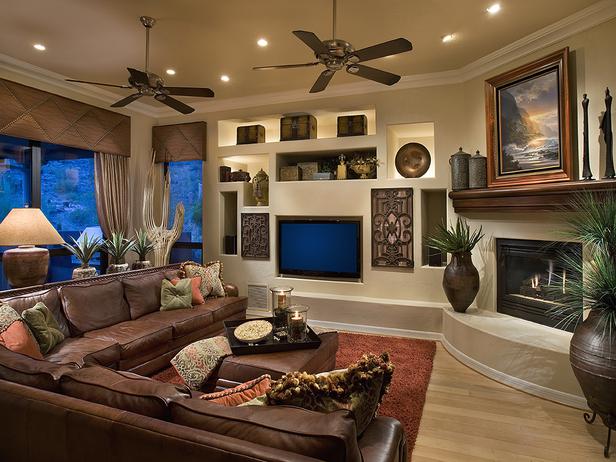 A living room with brown leather furniture and a fireplace that features lighting.