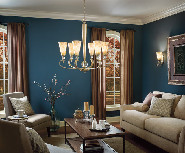 A living room with blue walls and a chandelier that provides lighting.