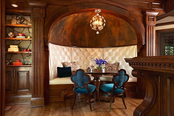 A dining room with a wooden table and banquette seating.