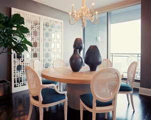 A dining room with a round table and folding chairs.