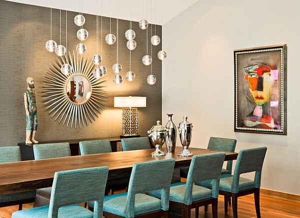 A modern dining room with turquoise chairs and a chandelier decorated with mirrors.
