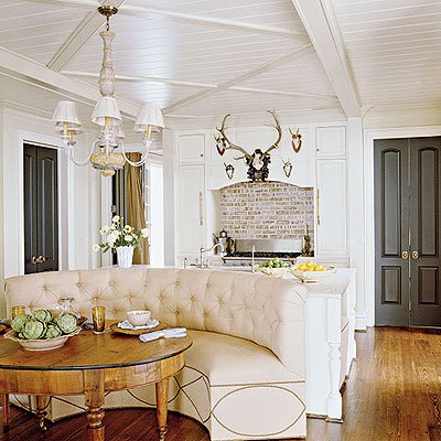 A white kitchen with banquette seating.