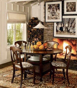 A dining room with zebra print chairs and a fireplace.