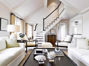 A white living room with a staircase, decorated elegantly in white.