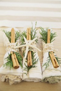 Four festive napkins adorned with cinnamon sticks and star anise.