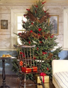 A festive living room with a Christmas tree and chairs.