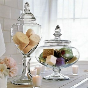 Glass jars with soaps and candles on a bathroom counter exemplify the allure of decorating with glass jars.
