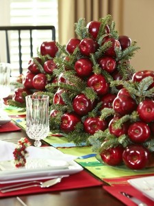 Festive Christmas table setting with red apples and pine cones.