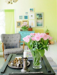 A living room with pink flowers on a table balanced through asymmetric interior design.