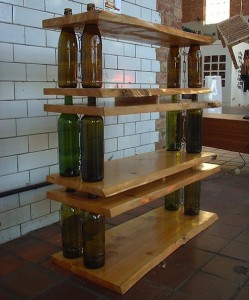 A creative wooden shelf with wine bottles on it.