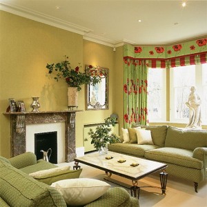 A living room with green furniture and a fireplace, decorated in green.