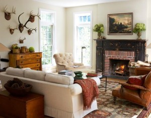 A rustic living room with a fireplace and deer antlers.
