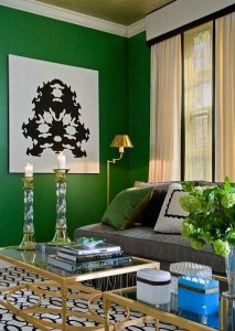 A living room decorated with green walls and gold accents.