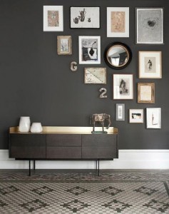 A room with black walls and framed pictures on the wall showcasing proper balance.