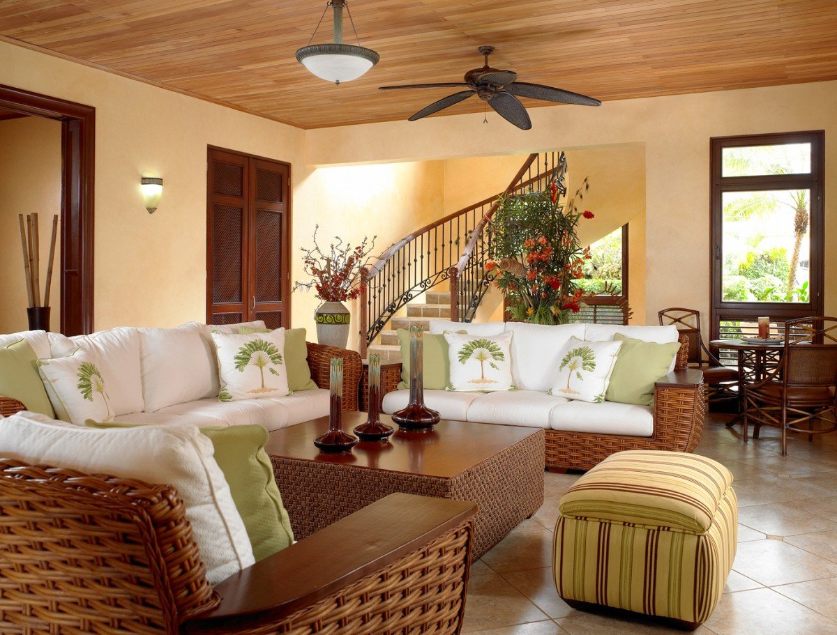 A tropical living room with wicker furniture and a ceiling fan.